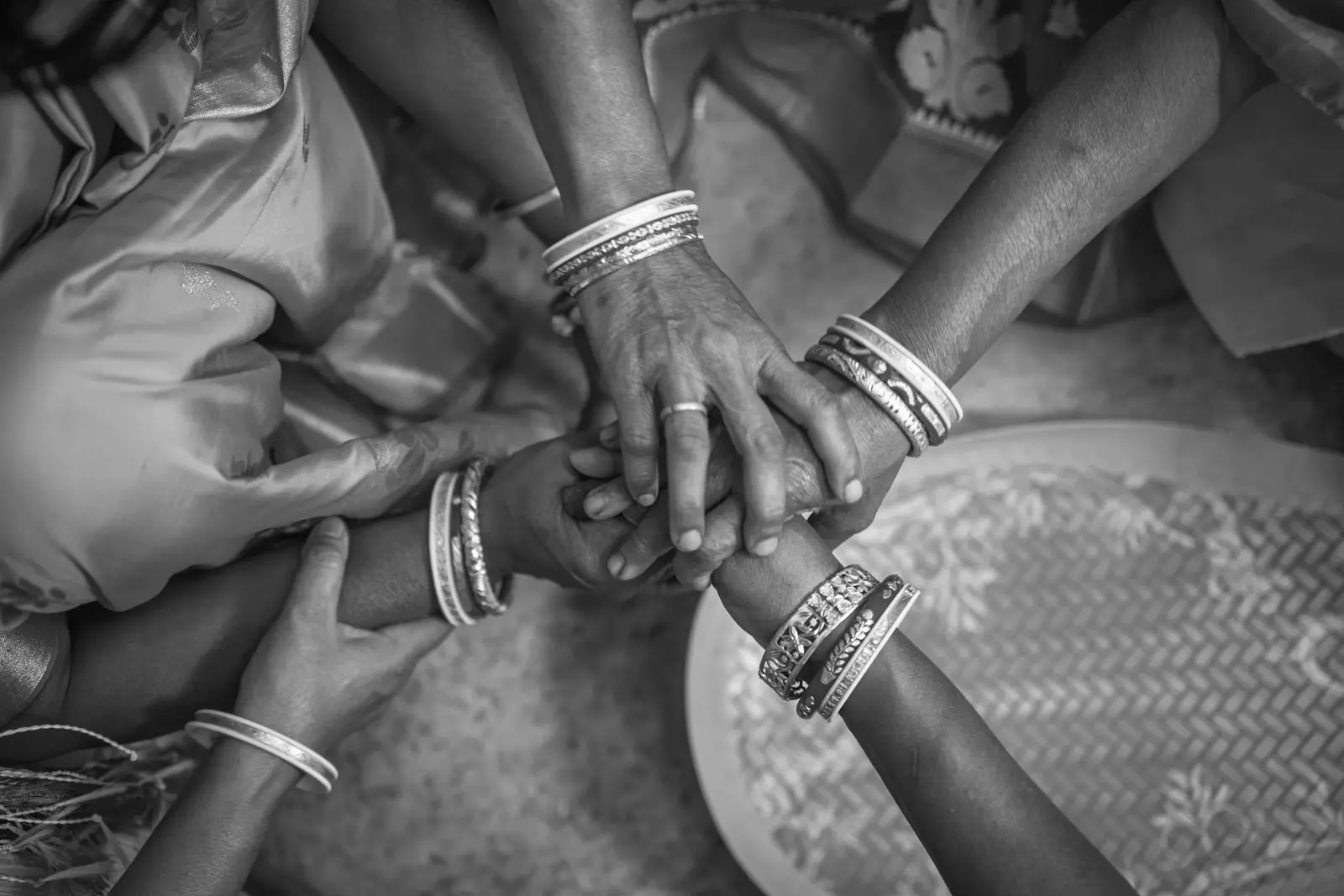 Women's hands joined together, wearing Bengali shankha bangles